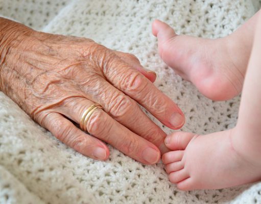 Dłoń babci i nóki niemowlęcia
